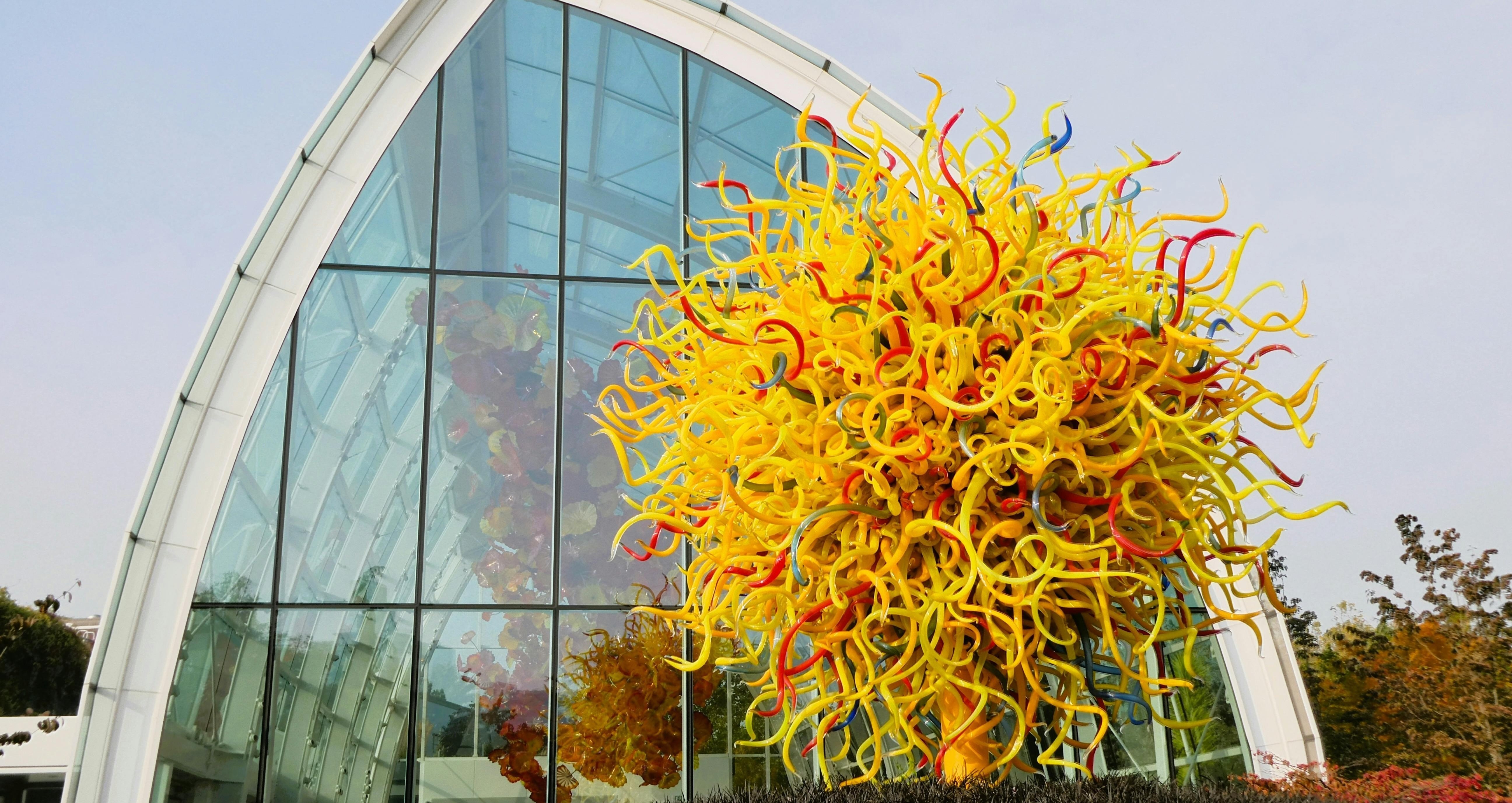 image of a yellow glass sculpture in front of a glass building
